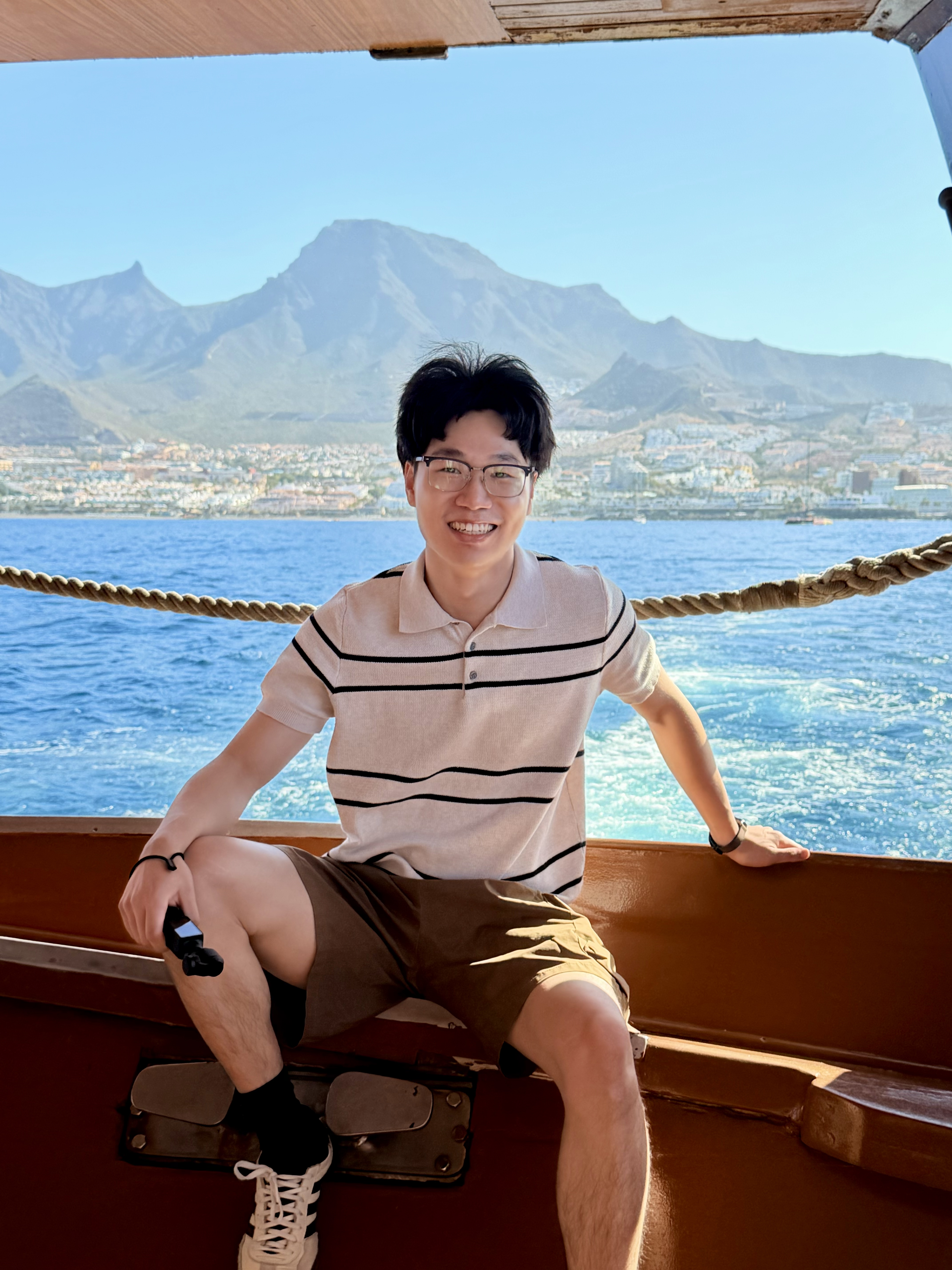 Gang Yang by the sea with mountains in the background